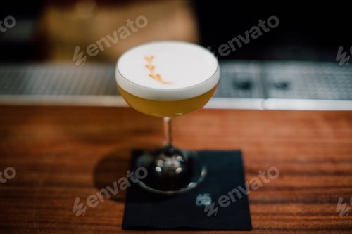 Preview: Elegant Cocktail with Foamy Topping at a Bar