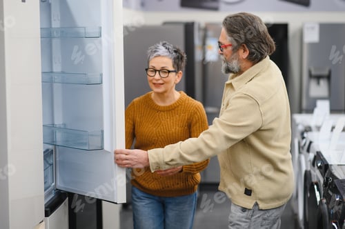 Preview: Mature couple choosing new refrigerator in appliance store