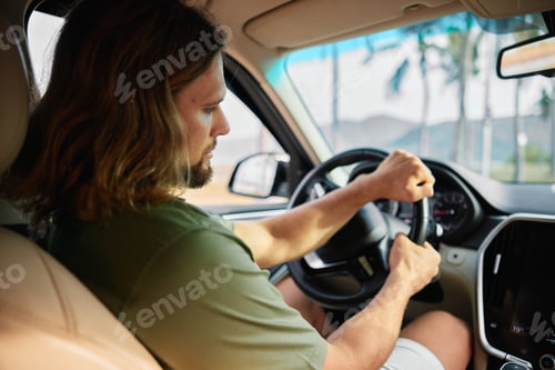 Preview: A man driving a car with focus and determination on a sunny day, palm trees visible in the