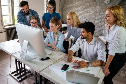 Preview: Group of young multi-ethnic startup business team collaborating on project in modern office