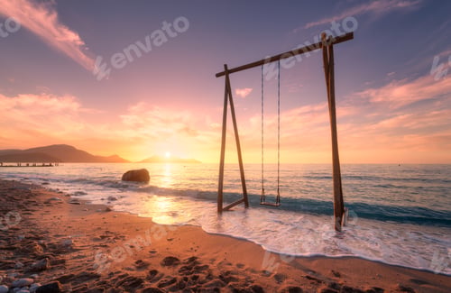Preview: Wooden swing in beautiful blue sea with waves, sandy beach
