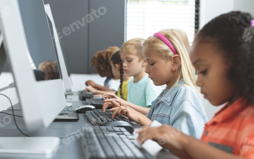 Preview: Side view of school kids taping on their keyboard in a computer room at school