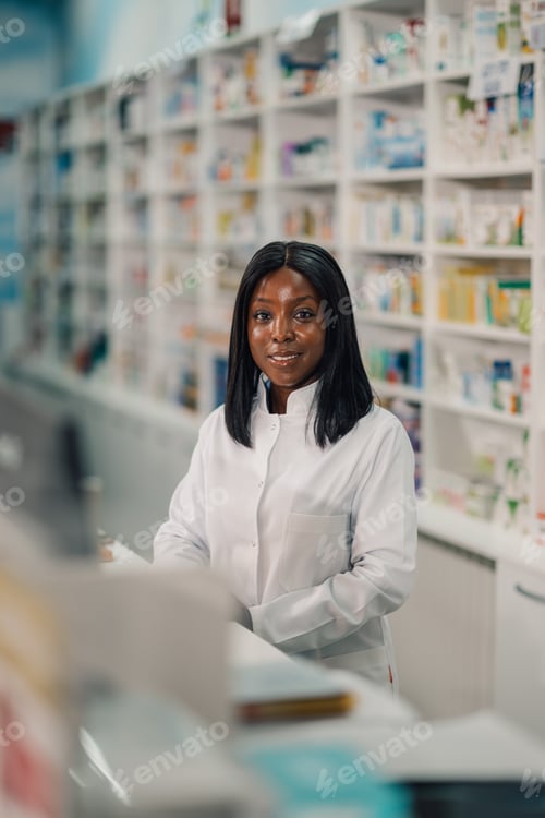 Preview: Close up of diverse pharmacist at counter in apothecary smiling at camera