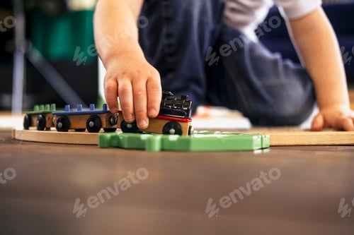Preview: Close-up of children's hands playing with engines on the floor at home. The kid spends time playing