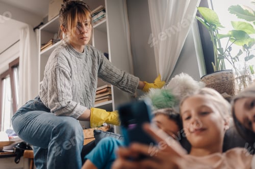 Preview: Mother cleaning while children using smartphone at home