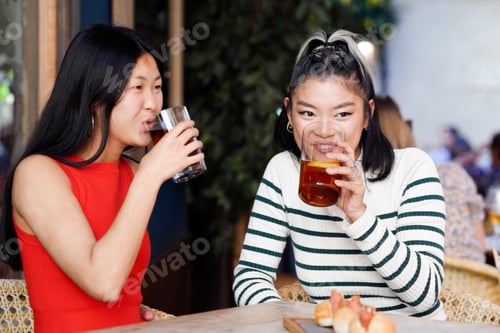 Preview: Friends enjoying coffee and pastries. Two ladies sharing joyful moments over snacks