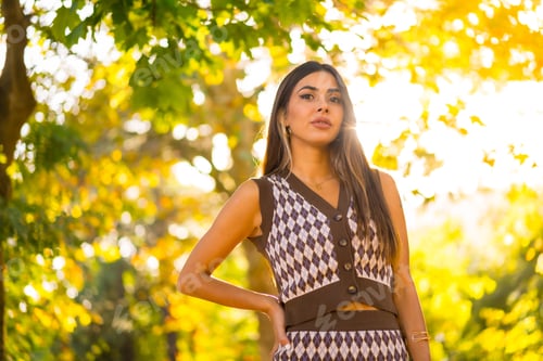 Preview: A caucasian brunette woman in autumn at sunset in a natural city park