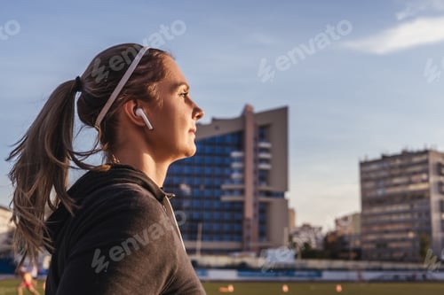 Preview: Woman running in stadium, close-up. Female runner training outdoor in profile. Healthy lifestyle ima