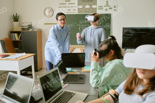 Preview: Teenagers and Caucasian Woman Teacher Using Virtual Reality Headsets in Classroom