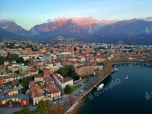 Preview: Drone view of Lake Como surrounded by a town and mountains in the evening in Italy