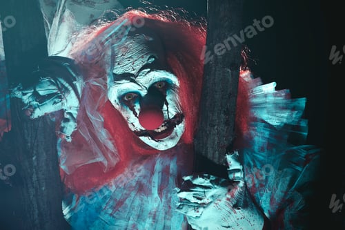 Preview: Terrifying clown hiding behind trees outdoors at night. Halloween party costume
