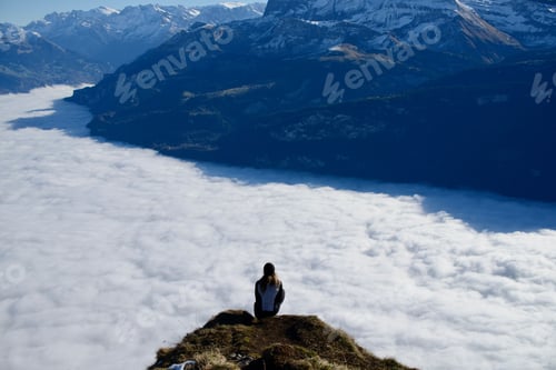 Preview: Female atop a grassy hill enjoying the mountainous view of Bernese Highlands