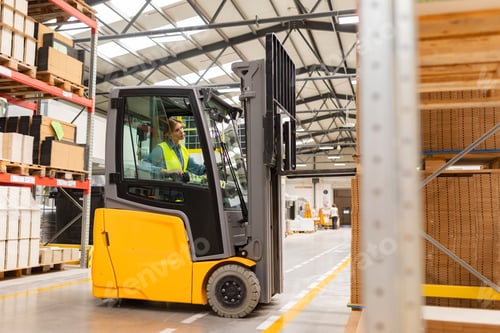 Preview: Female warehouse worker driving forklift. Warehouse worker preparing products for shipmennt