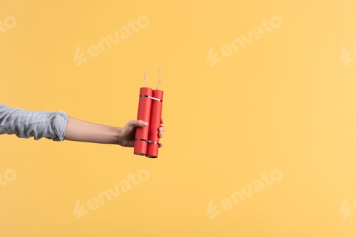 Preview: cropped view of woman holding dynamite in hand, isolated on yellow