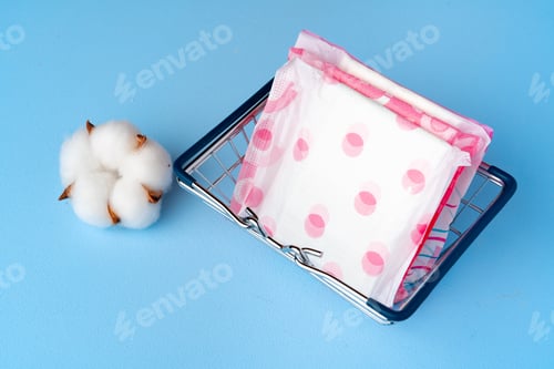 Preview: Female pads in shopping cart on paper background