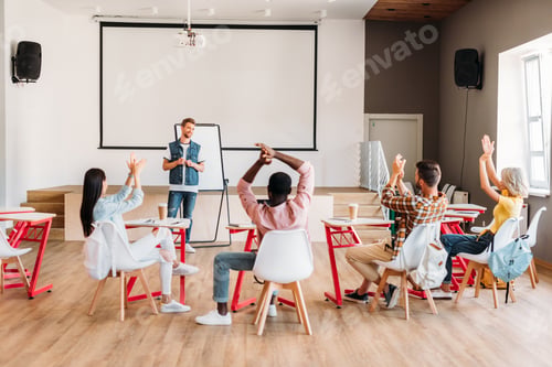 Preview: rear view of multiethnic young students clapping to lecturer after presentation at college