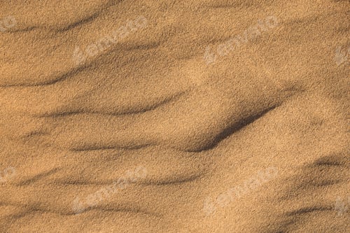 Preview: Texture of sand in the desert close-up background. A dune with a pattern of sand waves