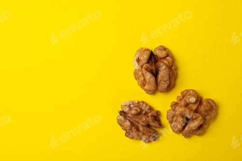 Preview: Tasty walnut on yellow background. Vitamin food