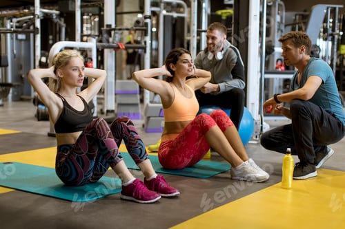 Preview: Young athlete doing stomach workout in modern gym