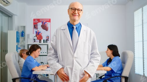 Preview: Portrait of elderly man surgeon standing in front of camera smiling
