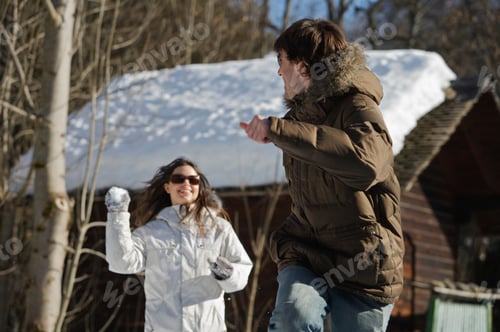 Preview: Couple in casual ski wear, throwing snow
