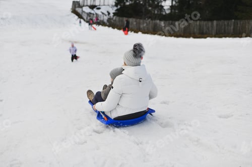 Preview: A family sledding in the snow