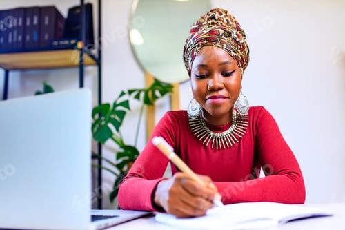 Preview: Image of african american woman with turban over head using laptop in office