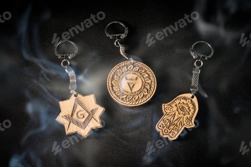 Preview: Amulets made of wood with a metal hook on a black background