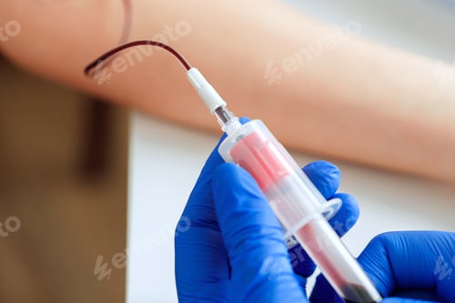 Preview: Hands of a doctor taking blood samples using a tube holder