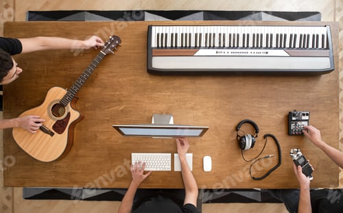 Preview: Top view of a wooden table with musical instruments and a computer. Musical creativity concept.