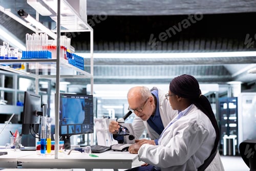 Preview: Two researchers conducting microscopy experiment in modern laboratory