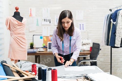 Preview: Young pretty tailor concentrating in fashion studio