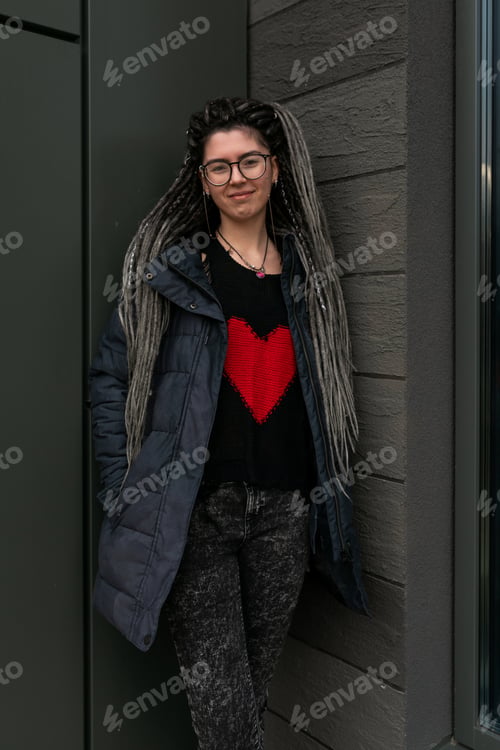 Preview: Lifestyle concept, young European woman with pigtails in her hair walking around the city