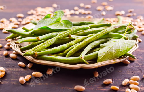 Preview: Heap of green pods of raw, not cooked, asparagus beans and white beans on a table
