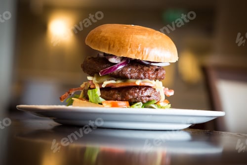 Preview: Delicious classic cheeseburger served on a white plate on a wooden table in a restaurant