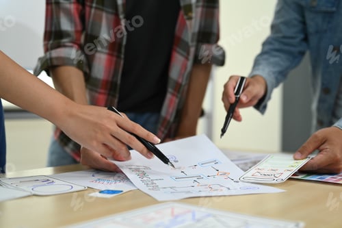Preview: Cropped shot of designer team working on new website wireframe at meeting.