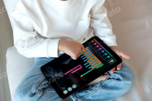 Preview: A preschool kid programmer coding at tablet pc, uses machine language