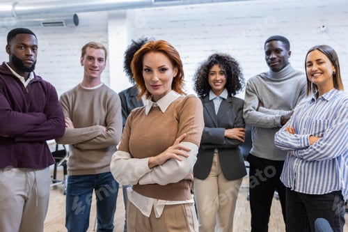 Preview: Confident business team posing with crossed arms in coworking space