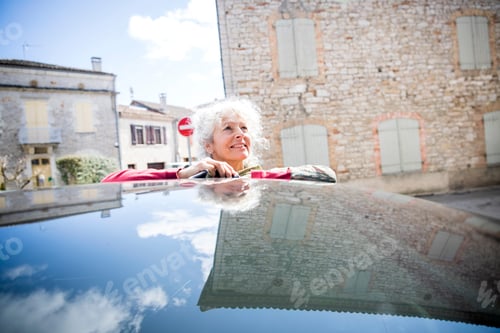 Preview: Woman by car looking away smiling, Bruniquel, France