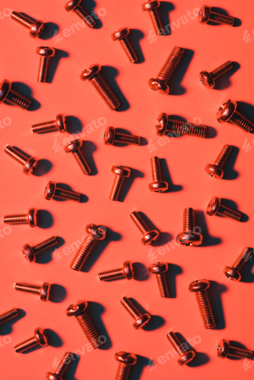 Preview: set of small metal screws on red