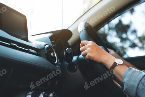 Preview: Closeup image of a woman holding steering wheel while driving a car