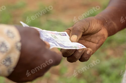 Preview: Farmers exchanging money in Kenyan shilling currency, focus on hands