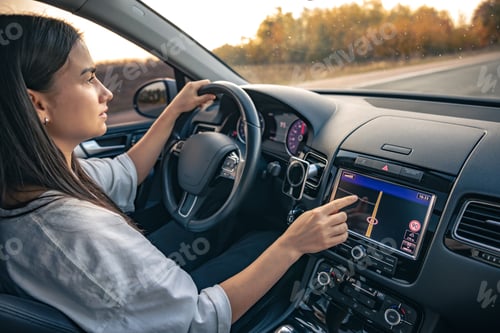Preview: Woman using navigation system while driving a car.