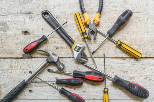 Preview: assortment of well-used hand tools spread out on a worn wooden surface