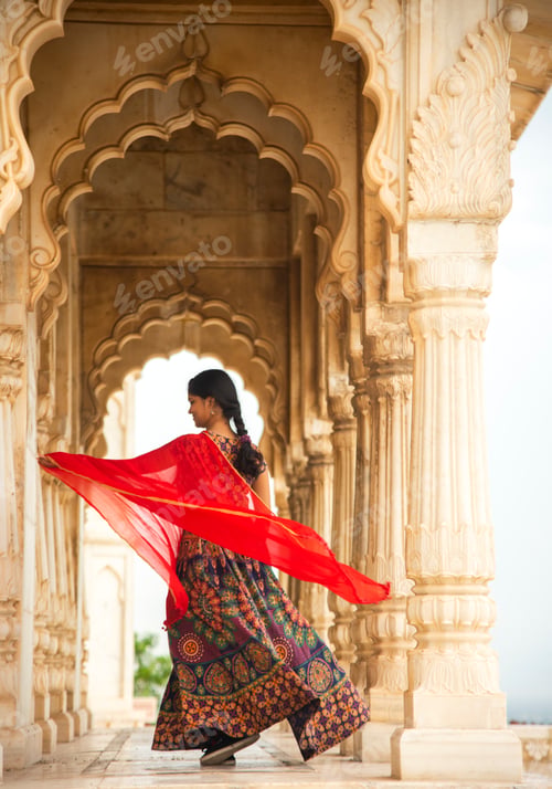 Preview: Young female tourist dancing between arches and Pillars.