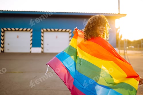 Preview: American lesbian woman holding LGBT rainbow flag. concept of happiness, love for same-sex couples.
