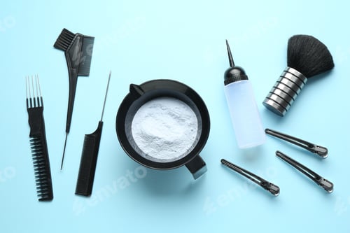 Preview: Bleaching powder and hairdresser's tools on light blue background, flat lay