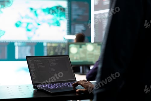 Preview: Governmental IT expert examines cyber threats on big screen and laptop
