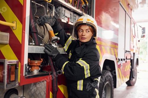 Preview: Taking equipment from the truck. Woman firefighter in uniform is at work in department