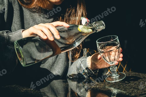 Preview: A woman in a cafe pours water into a glass.